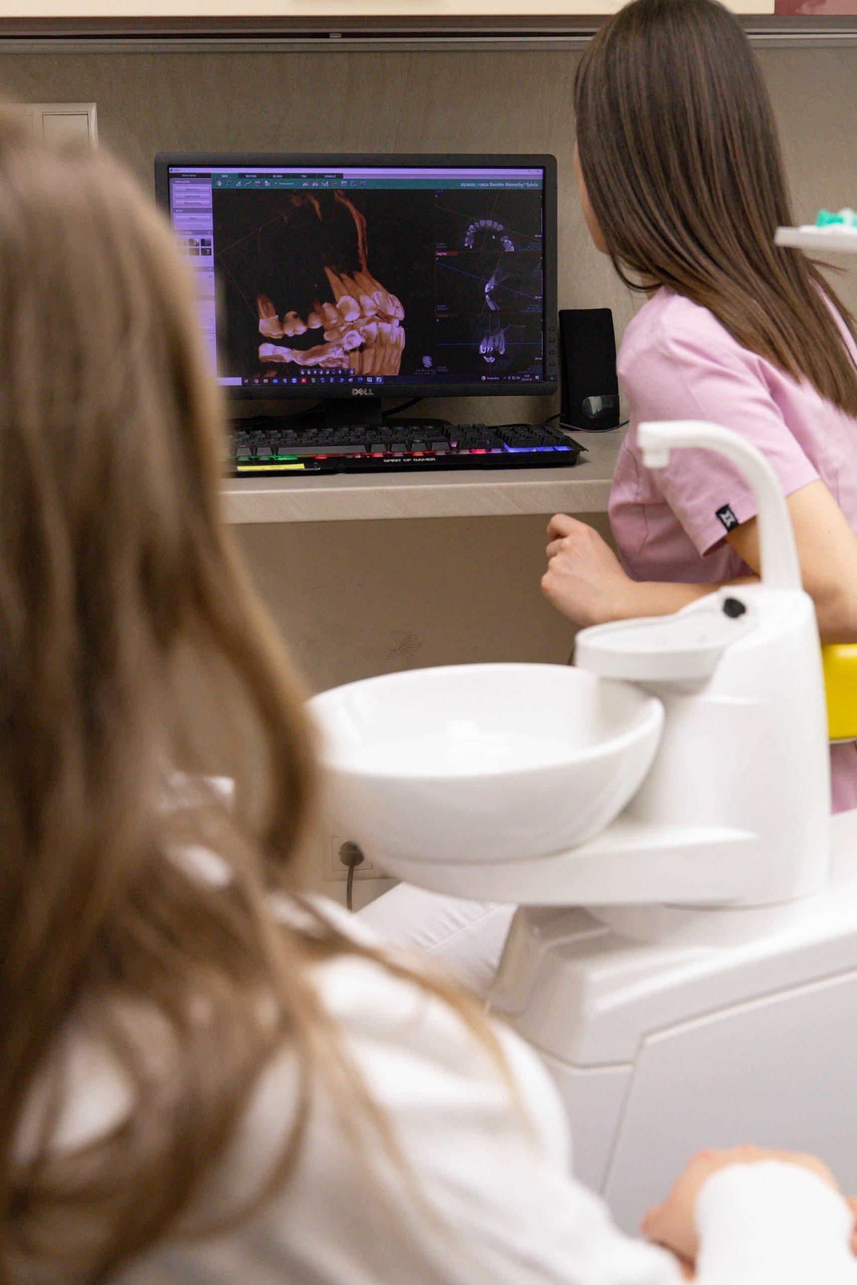 Fogászati konzultáció során fogászati röntgen vagy 3D fogszkennelés eredményét elemzik számítógépen a budapesti Centrocc Dental rendelőben